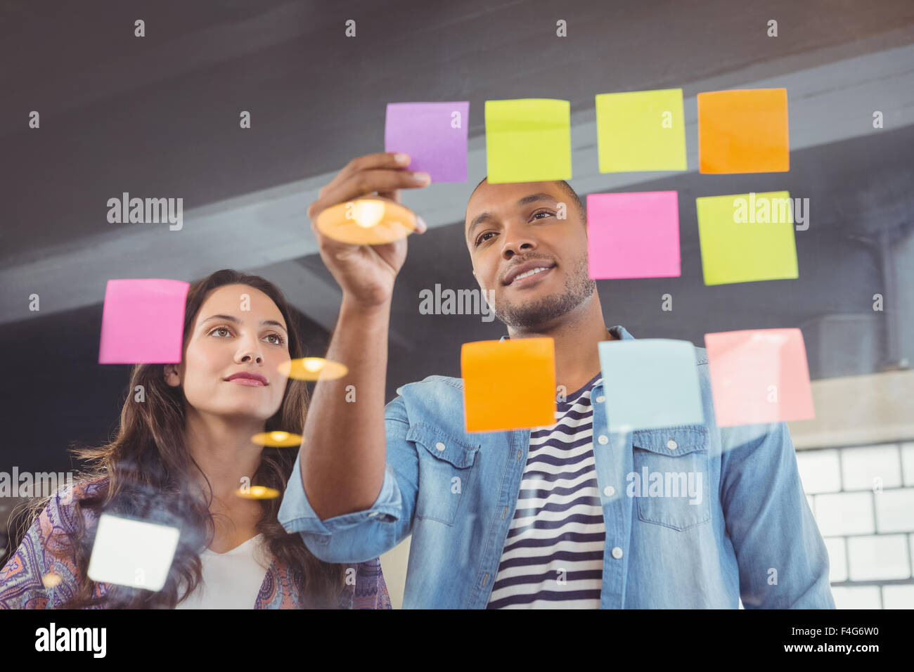 Creative team colleagues looking at sticky notes Stock Photo