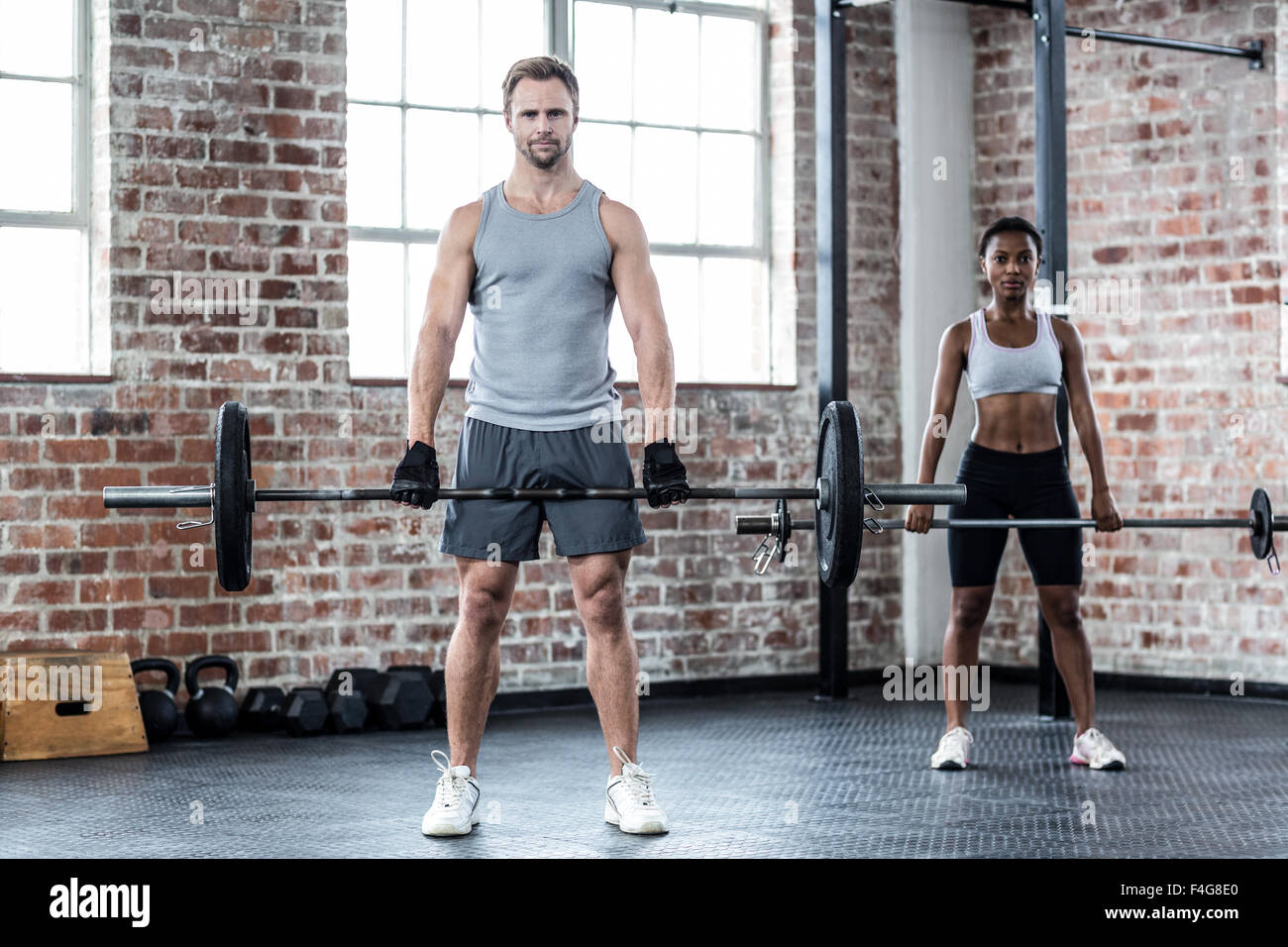 Fit couple lifting weight together Stock Photo - Alamy
