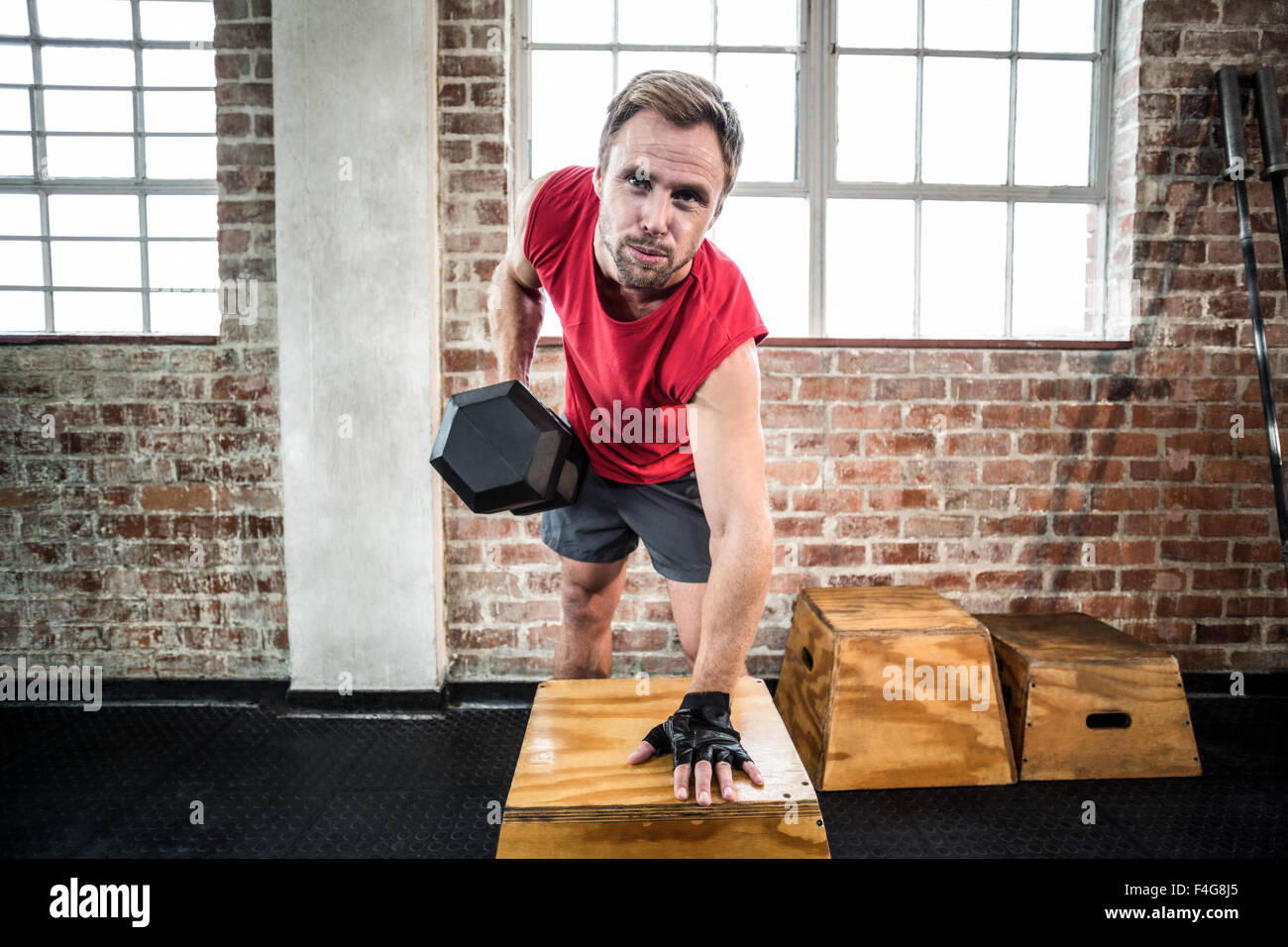 Muscular man lifting dumbbell lean on a box Stock Photo