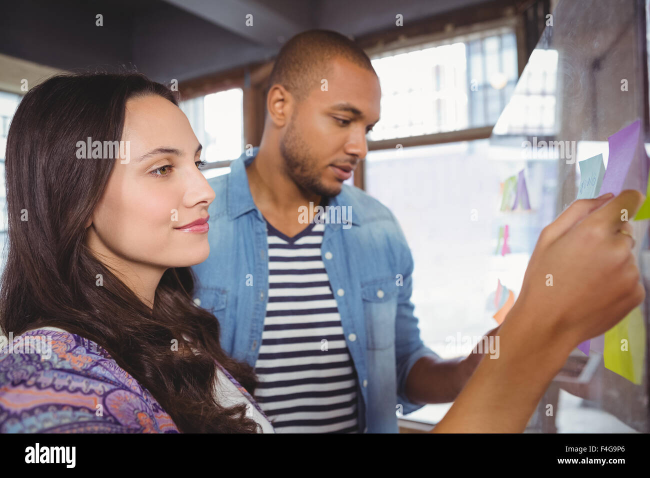 Woman and man looking at sticky notes Stock Photo