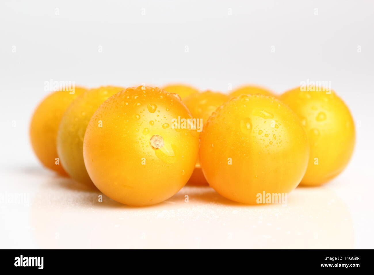 Yellow currant tomatoes with drops isolated on a white background. Macro. Stock Photo