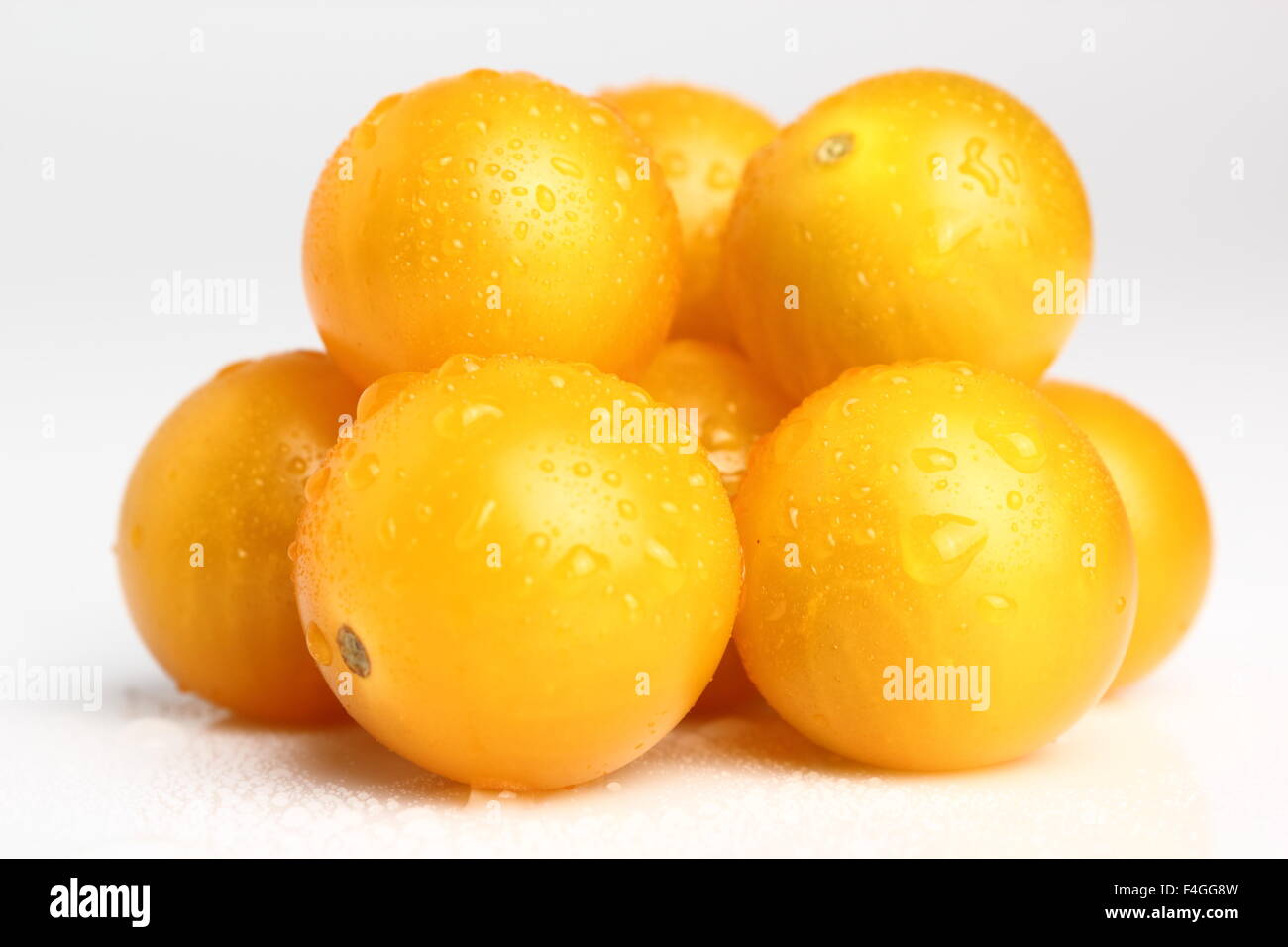 Yellow currant tomatoes with drops isolated on a white background. Macro. Stock Photo