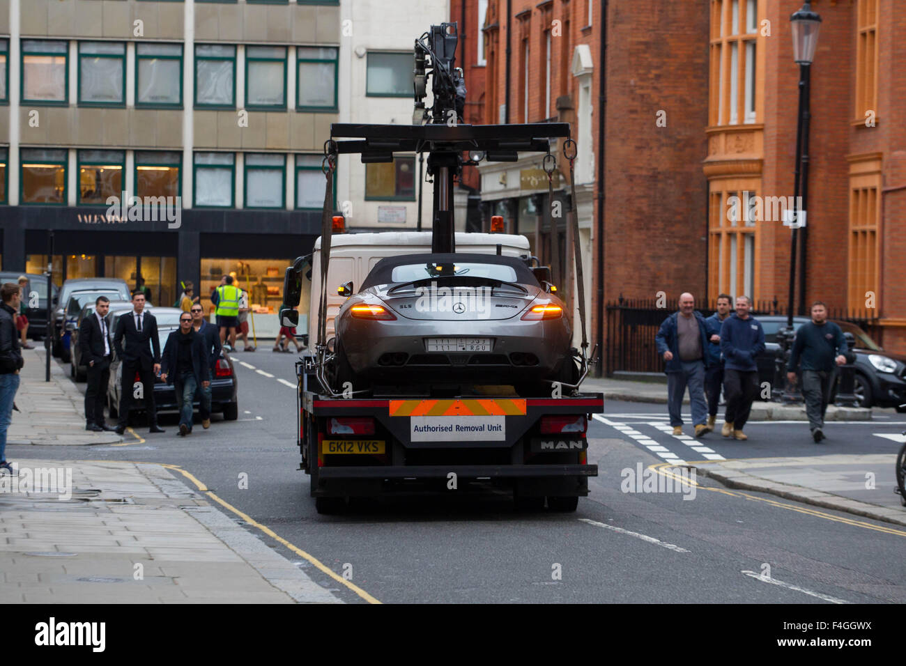 An illegally parked Mercedes SLS AMG Roadster is lifted from a London street by an 'Authorised Removal Unit' Stock Photo