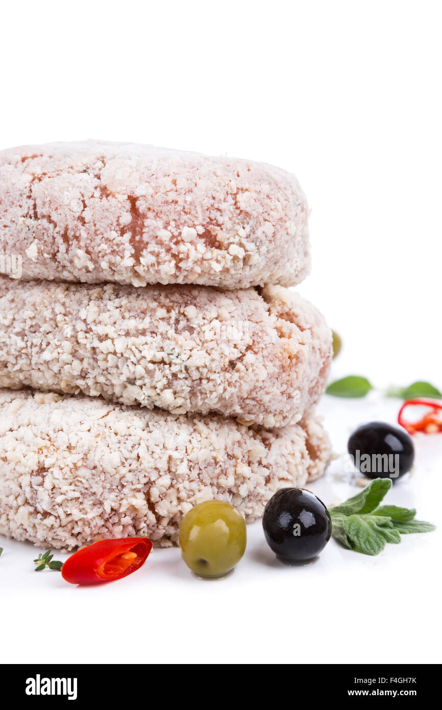 three raw cutlet with breading from on side on white background Stock Photo