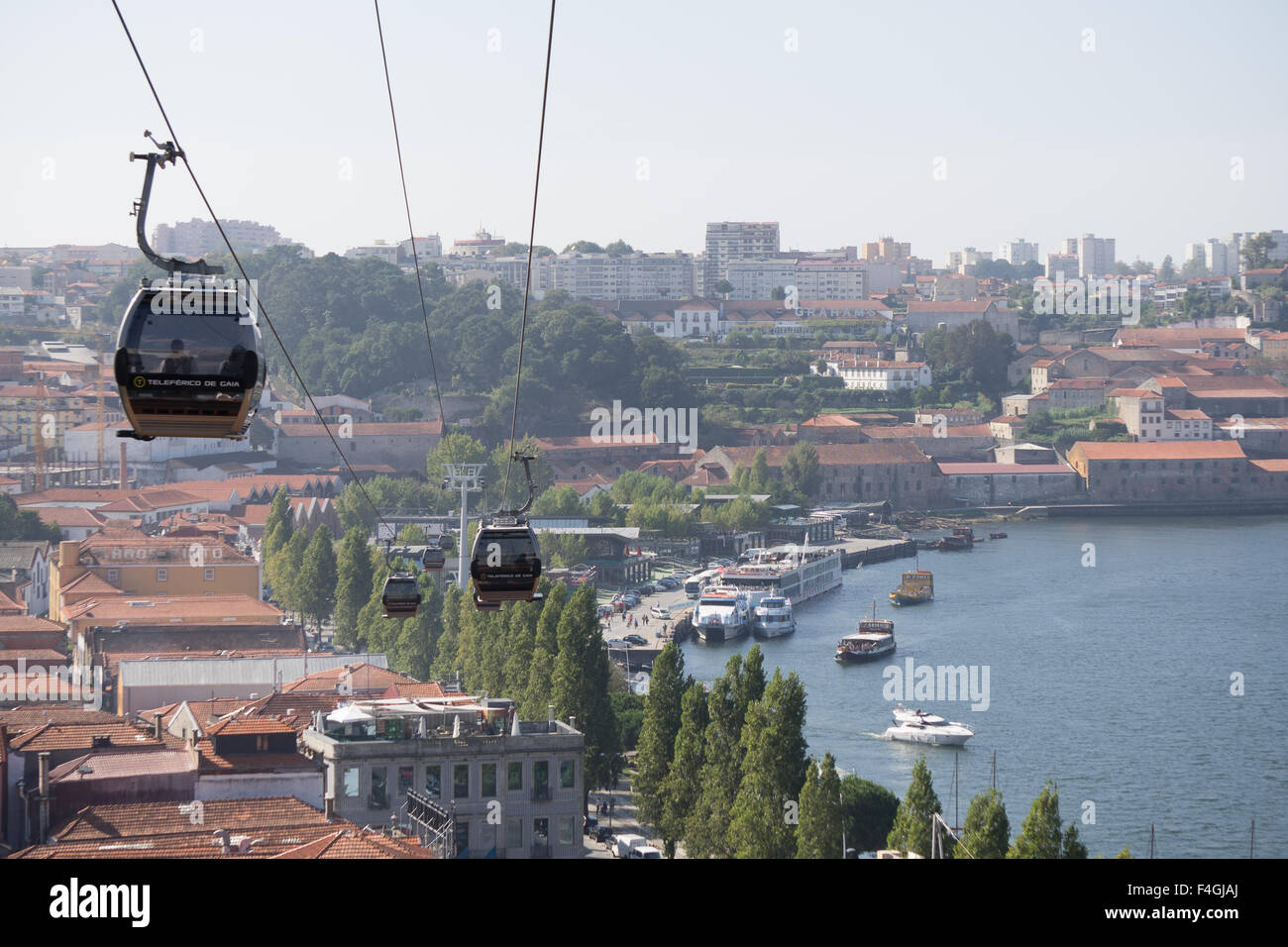 Cable cars fly over Gaia, the port wine lodge town, across the Ouro River from Porto. October, 2015. Porto, Portugal. Stock Photo