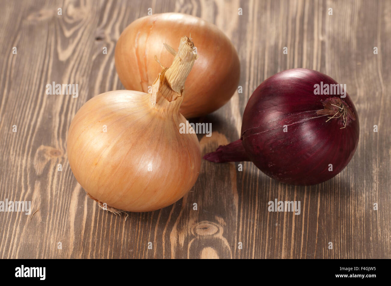 Red and yellow onions on a wooden table, closeup Stock Photo - Alamy