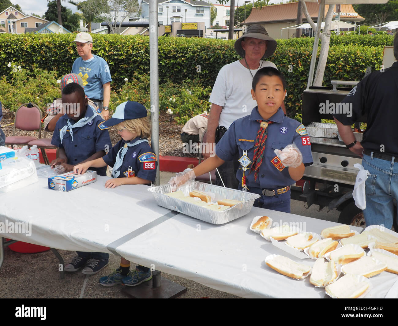 Black, White, and Oriental boyscouts prepare hot dogs for police fair. Redondo Beach, CA. Stock Photo