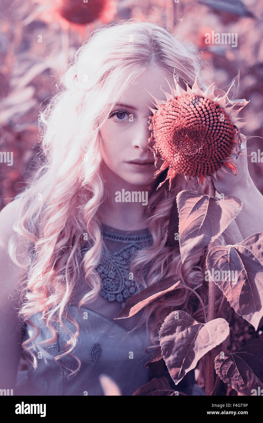 Beautiful blond woman in a sunflower field Stock Photo