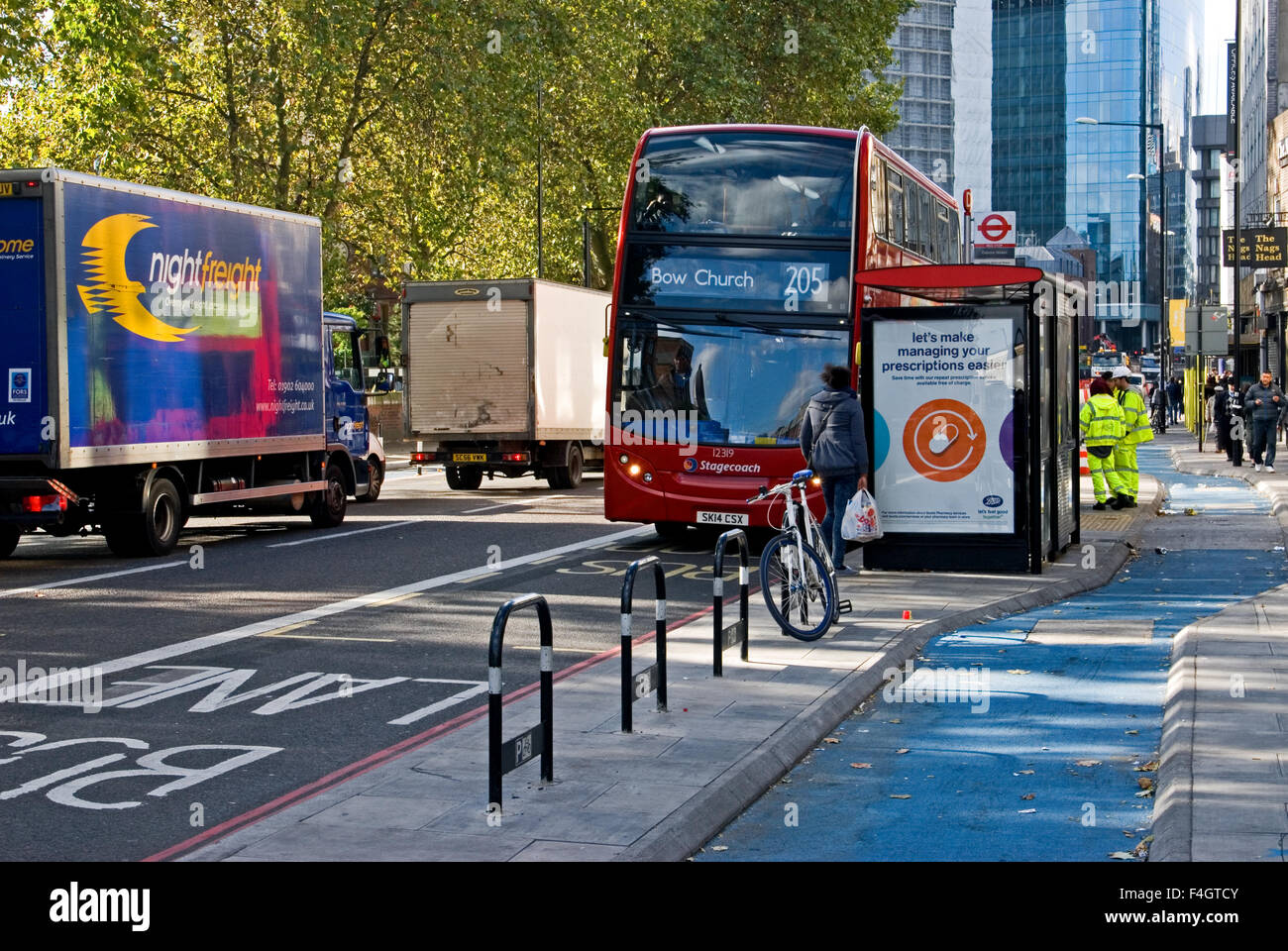 Investment in London's cycling infrastructure includes facilities at bus stops. Those now in use in Whitechapel, East London, super highway cycletrack Stock Photo