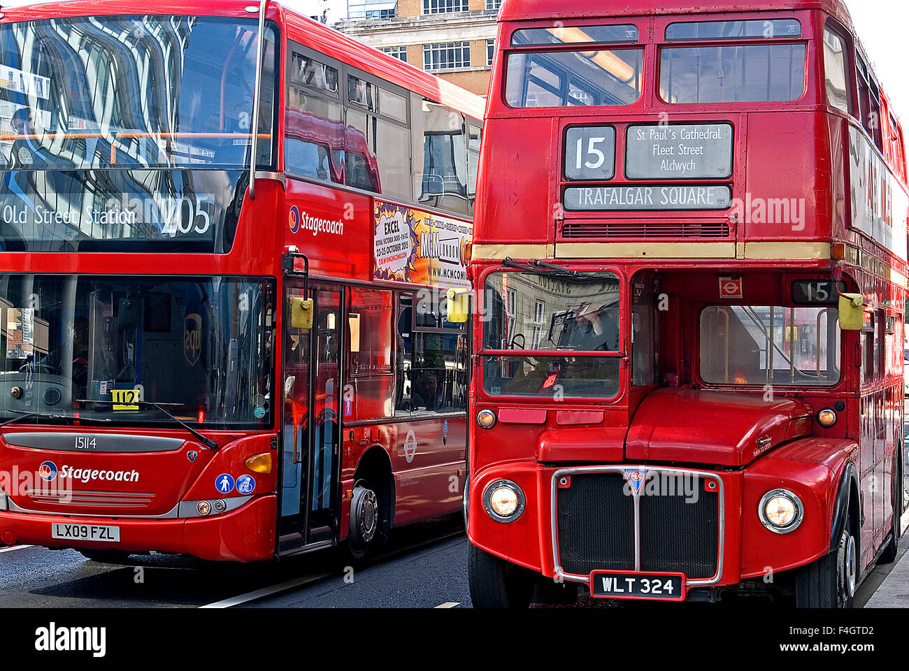Two red double decker London buses side by side in a street in Whitechapel, East London. Routemaster buses still operate as heritage transport. Stock Photo
