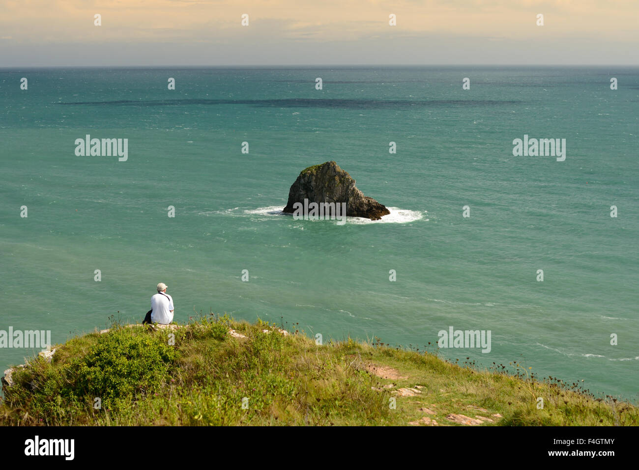 Man looking out to sea from a clifftop Stock Photo - Alamy