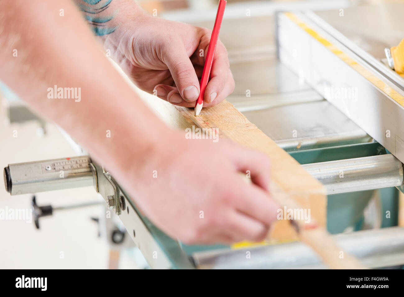 Carpenter measures the length of a wood plank before sawing Stock Photo