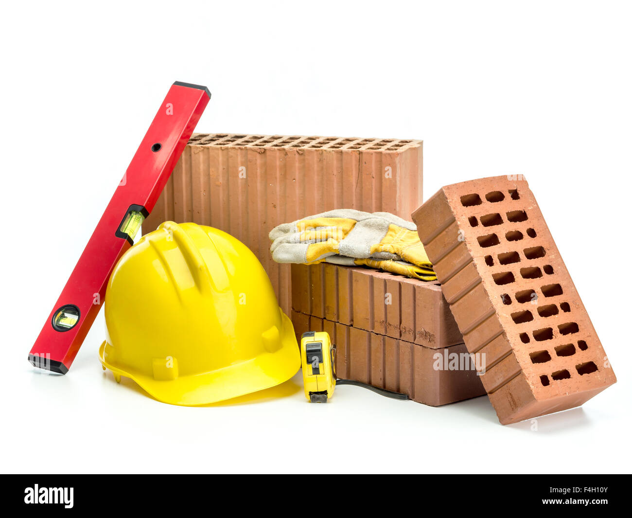 Perforated bricks, yellow helmet, protective gloves and spirit level isolated on white Stock Photo