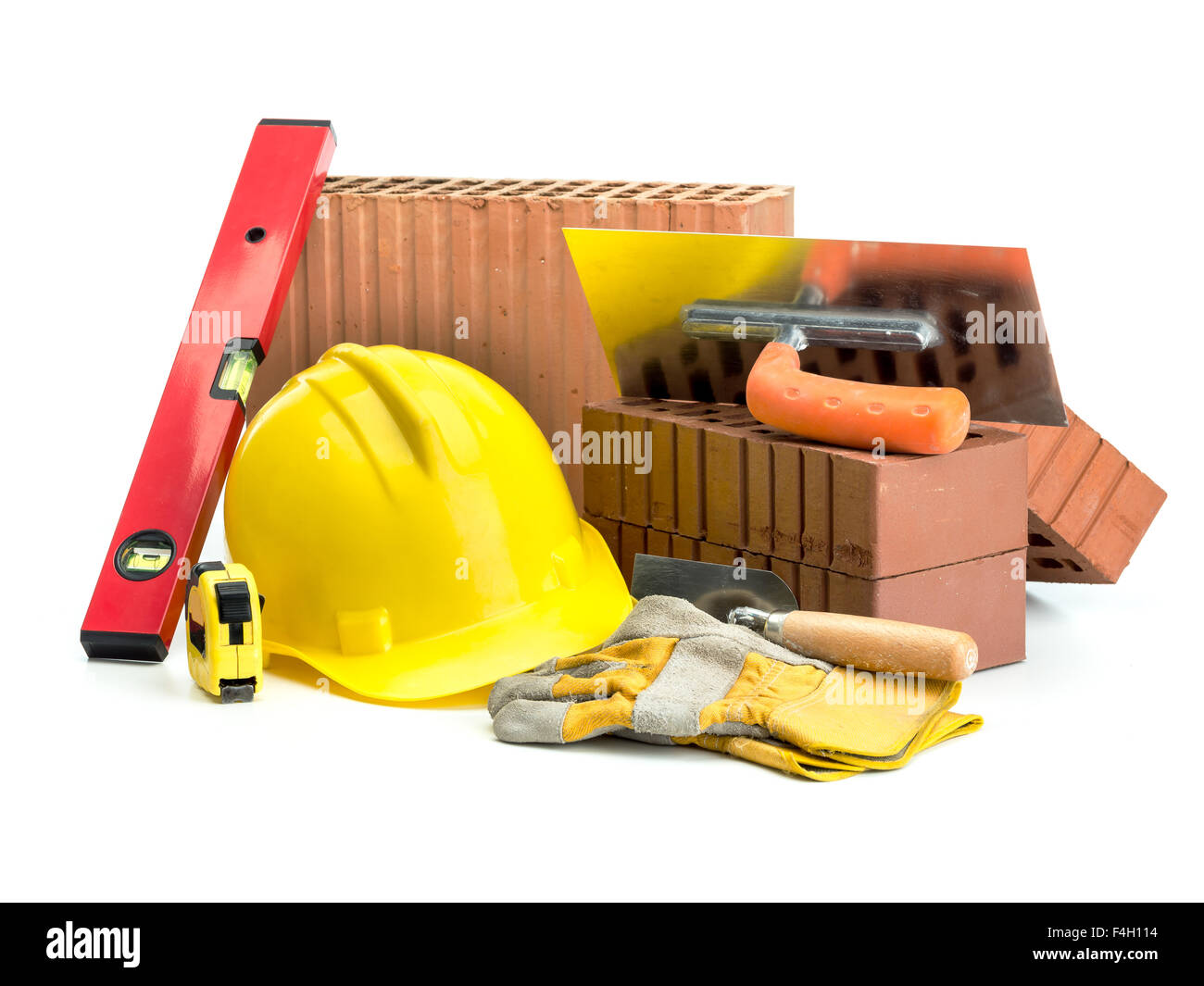 Perforated bricks, stainless steel trowel, yellow helmet, protective gloves and spirit level isolated on white Stock Photo