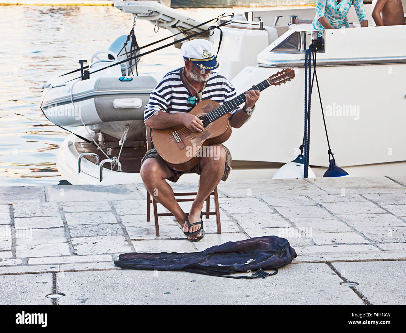 Trogir, Croatia - on the sea promenade a sea bear performs singing old sailor songs accompanied by his guitar Stock Photo