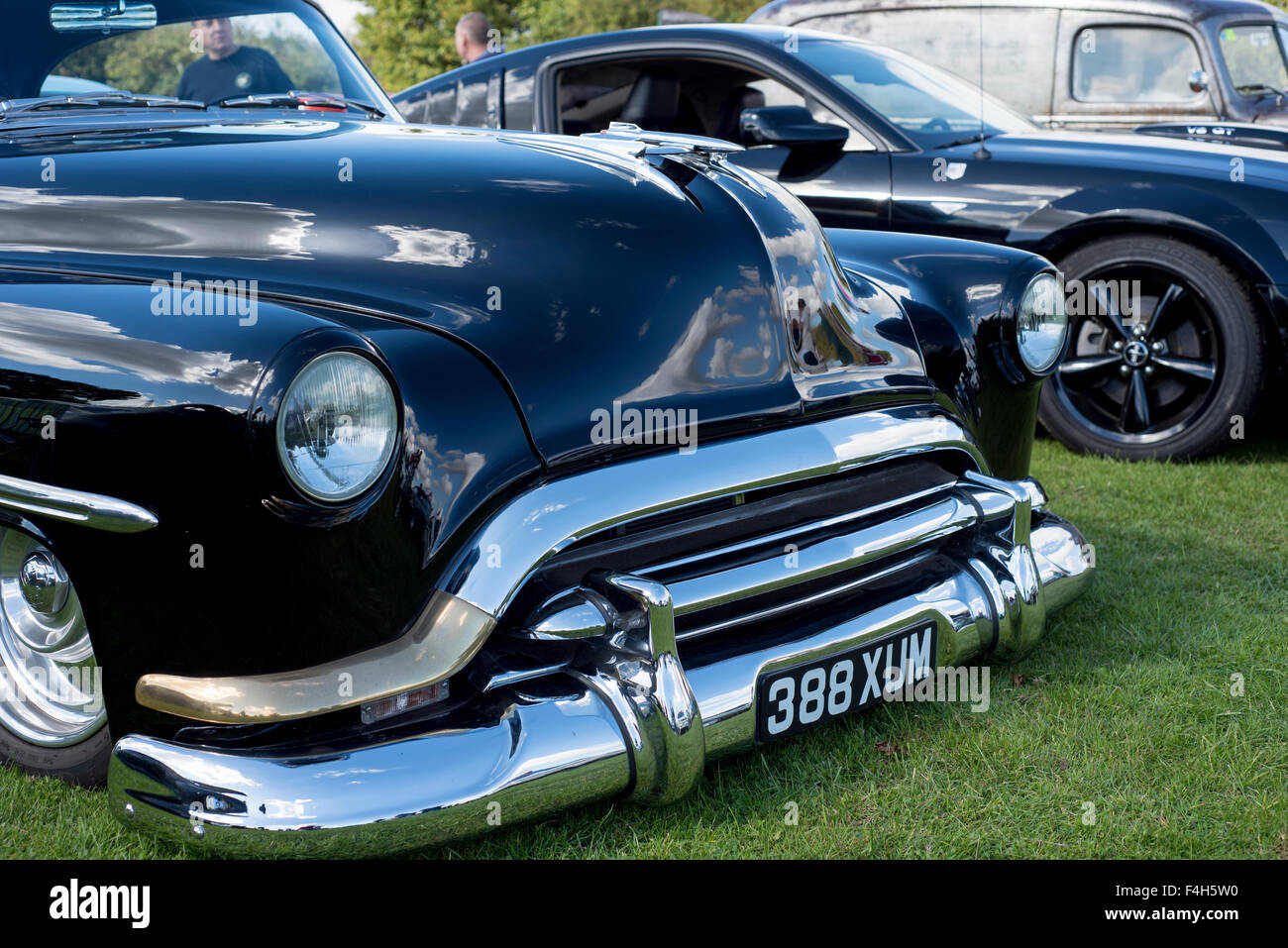 Grumpy Car, black saloon, U.S.A. car, bumper, silver, headlamps, reflection, emblem, windscreen, windscreen wipers, bonnet, hood Stock Photo