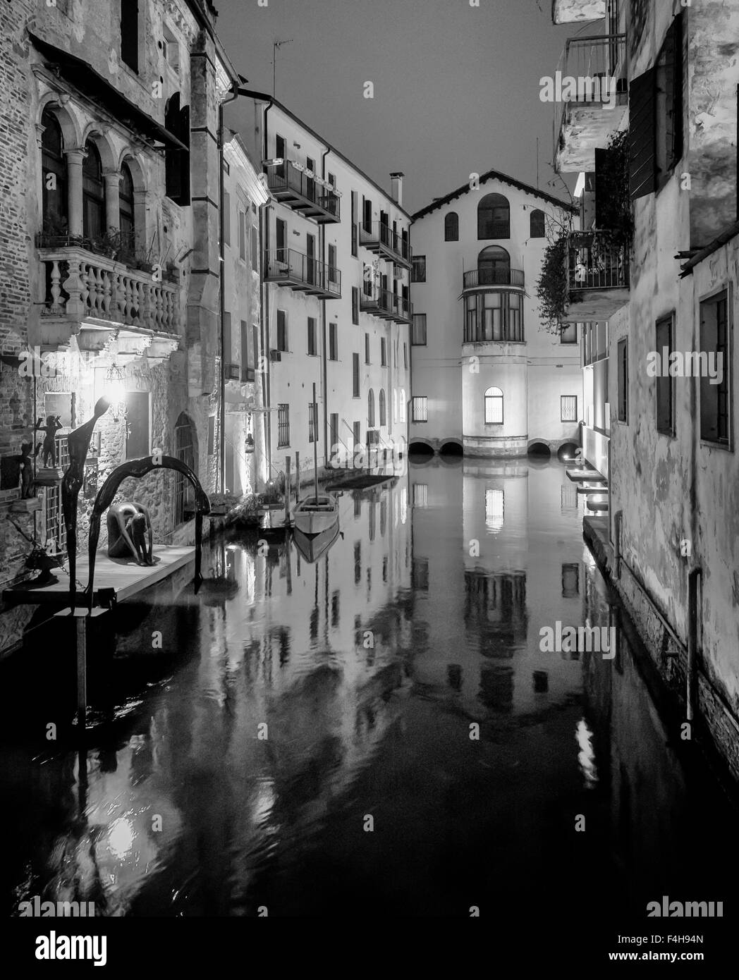 Night view of Treviso canal with surrounding buildings, typical italian architecture, vertical frame, b&w conversion Stock Photo