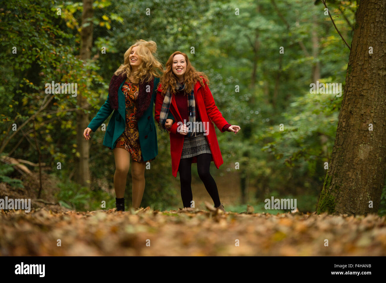 Aberystwyth Wales UK., Sunday 18 October 2015  Two happy smiling laughing young women (Iulia Nicola and Rhian Daniell) enjoying a Sunday afternoon stroll along a footpath in the autumnal woodlands at Penglais Park,  Aberystwyth, Wales   Photo Credit:  Keith Morris / Alamy Live News Stock Photo