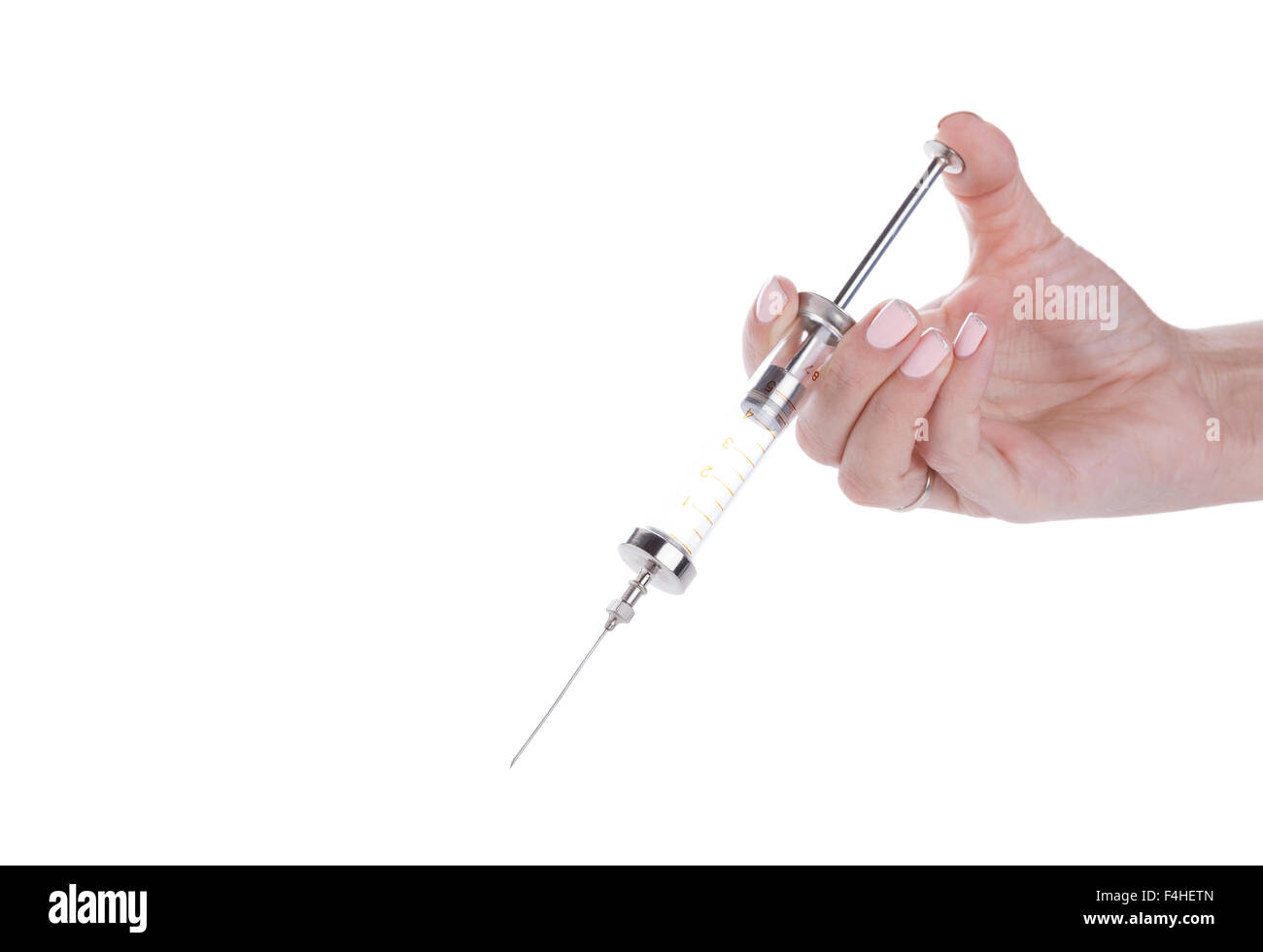 Old glass multiple use syringe in female hand, closeup on white background Stock Photo