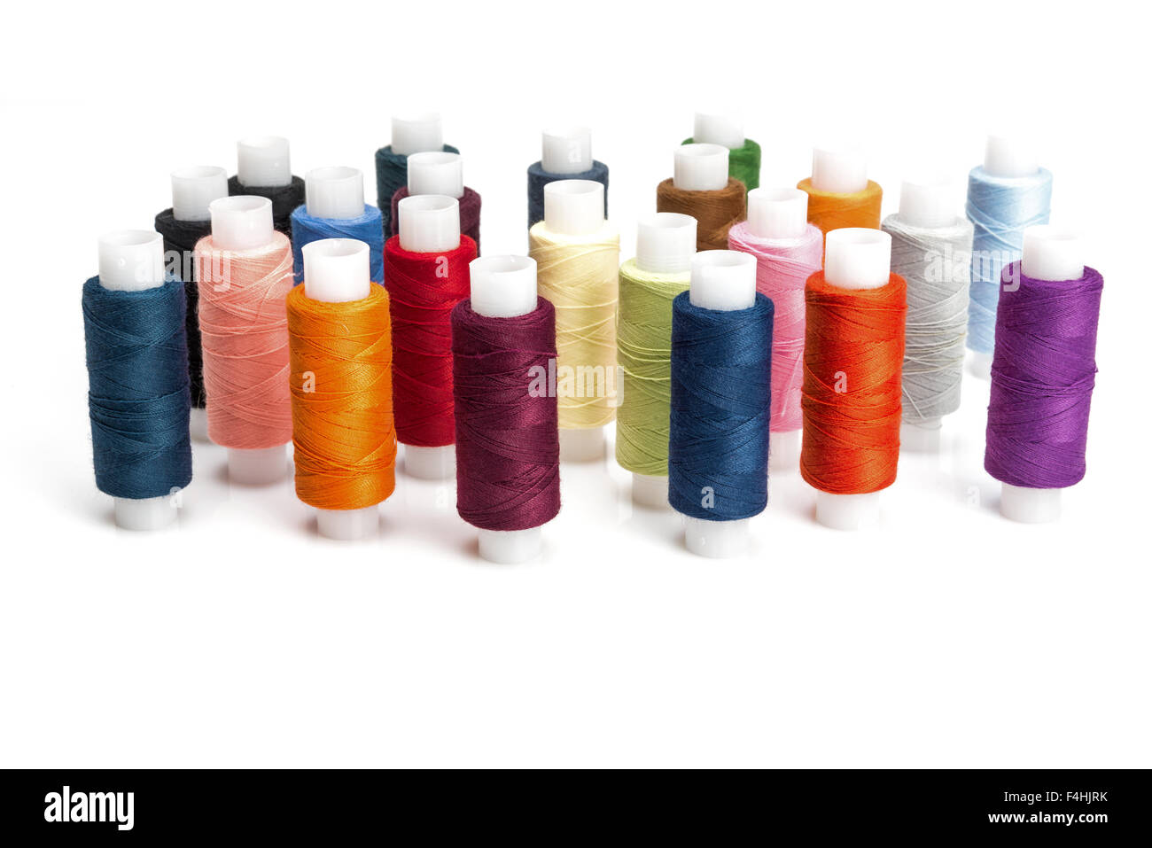 multicolored threads for sewing on spools isolated on white background Stock Photo