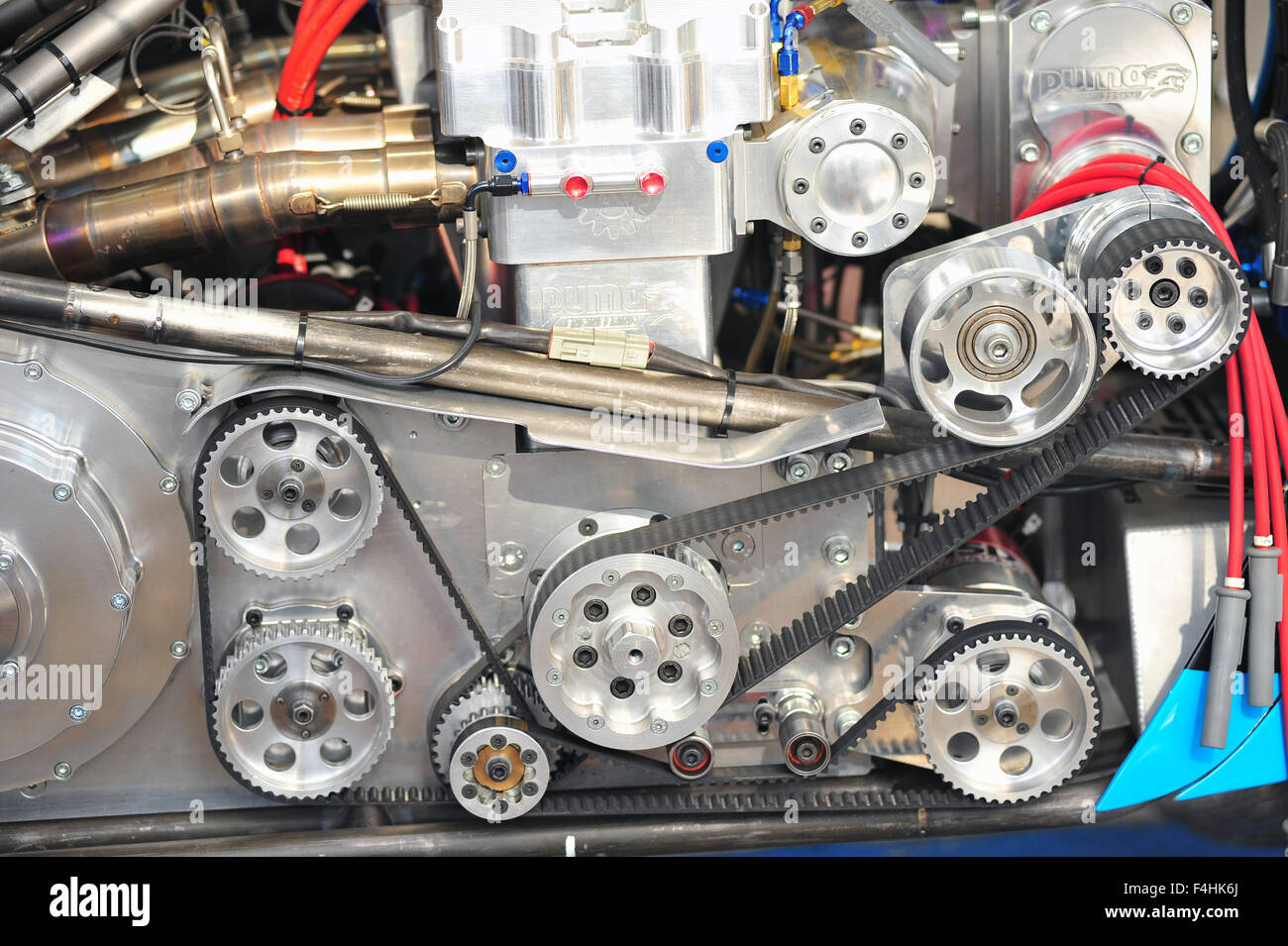 The auxiliary belts and wheels on the side of a racing engine at the