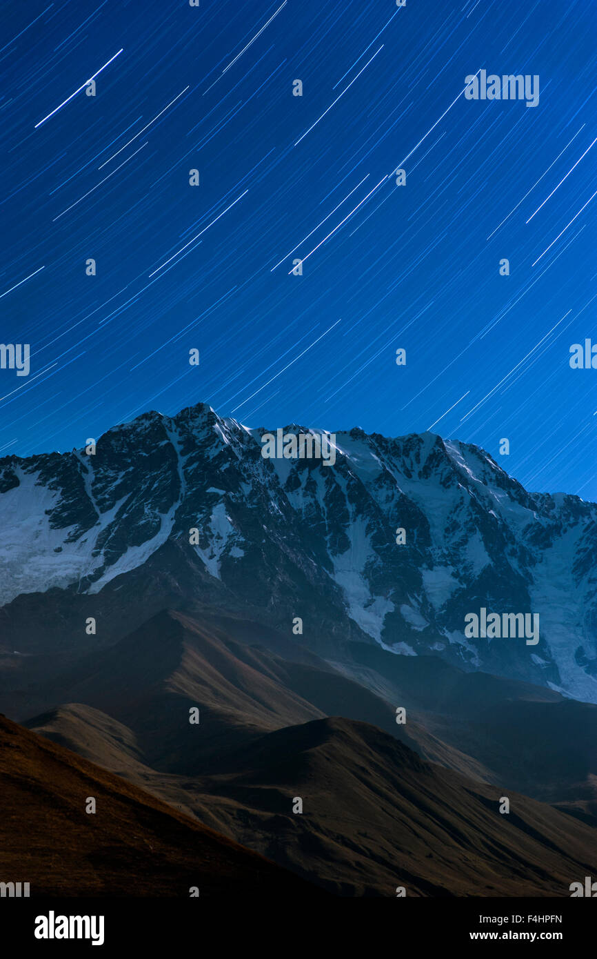 Moonlit view of star trails above Mount Shkhara (5193m), the highest mountain in Georgia. Stock Photo