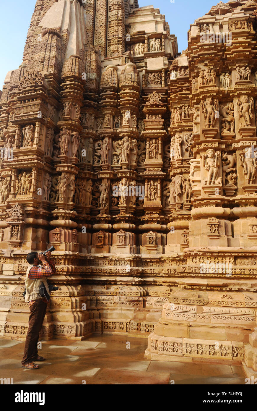 tourist taking the photo of stone carving at khajuraho temple india Stock Photo