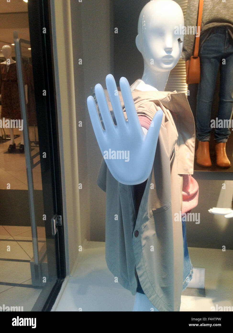 One dressed female mannequin in clothing store with stop hand symbol Stock Photo