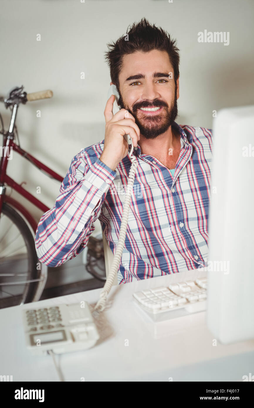 Portrait of happy man talking on landline phone Stock Photo