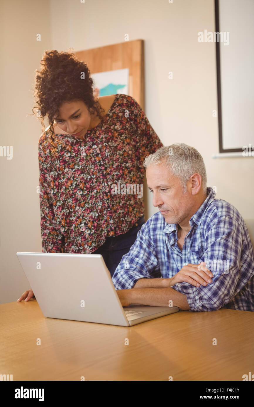Creative businessman with colleague looking in laptop Stock Photo