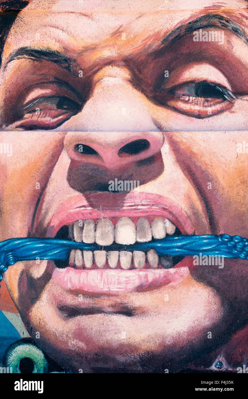 VALPARAISO, CHILE - OCTOBER 29, 2014: Colourful graffiti of an aggressive face with scarf between the teeth in Valparaiso, Chile Stock Photo