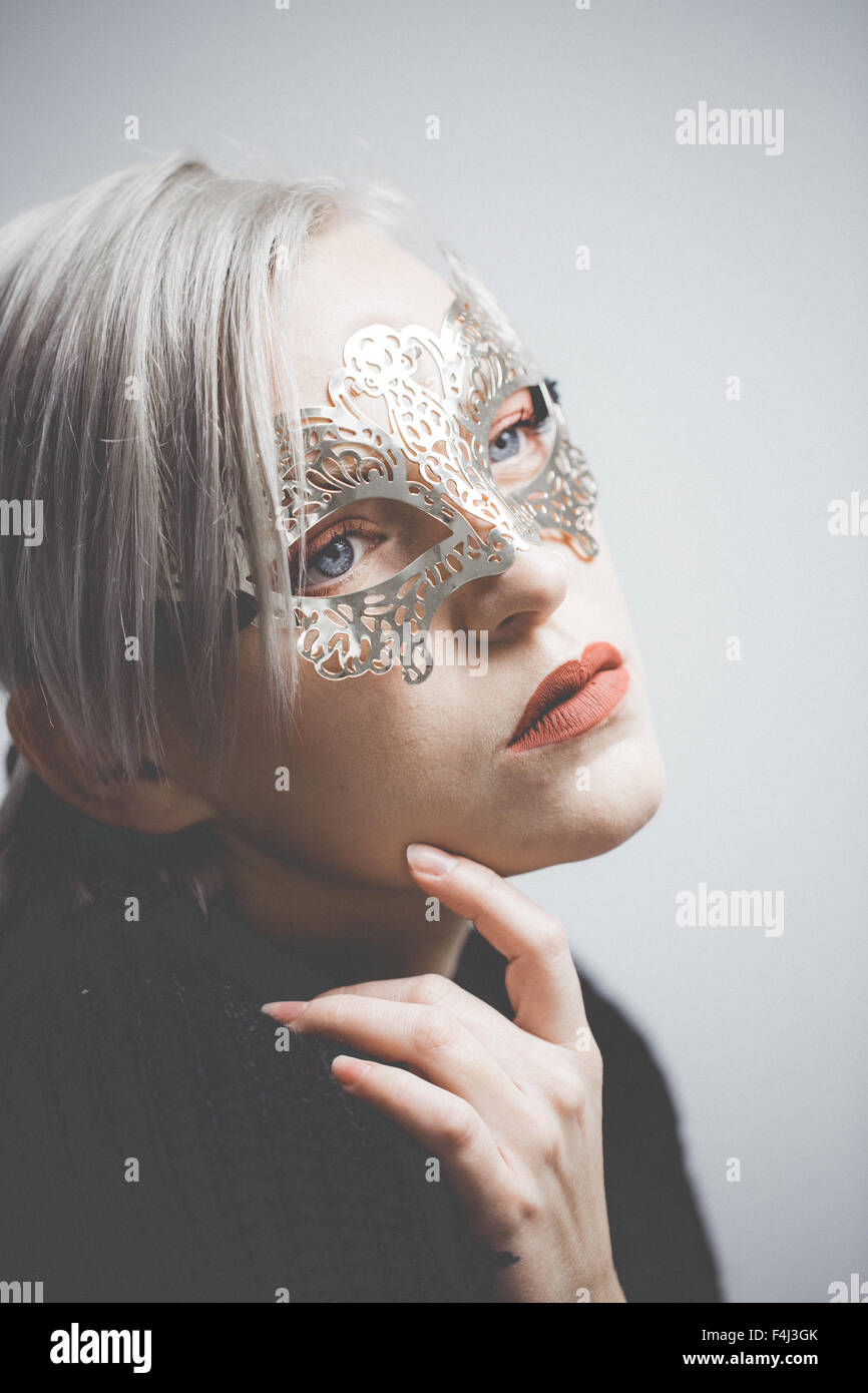 Girl wearing a gold decorative mask Stock Photo