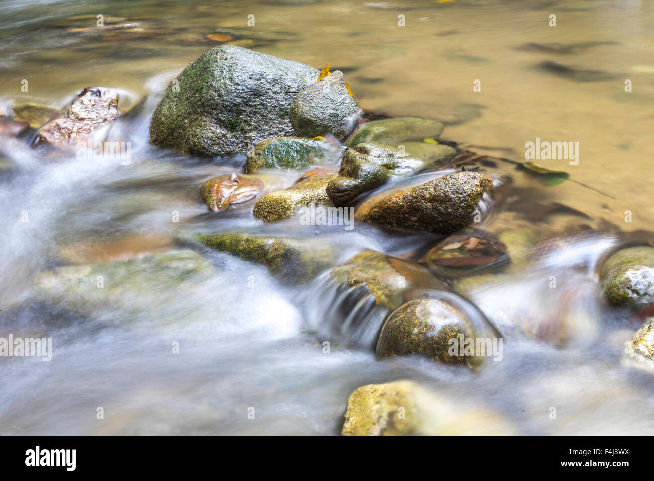 Natural flow of water stream in close up view Stock Photo - Alamy