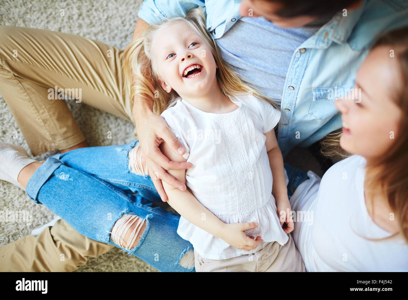 Ecstatic girl and her parents enjoying weekend at home Stock Photo - Alamy