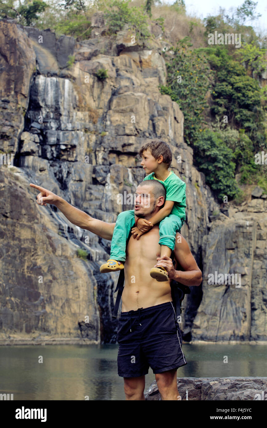 father and son making a trip to waterfall together, happy family on ...