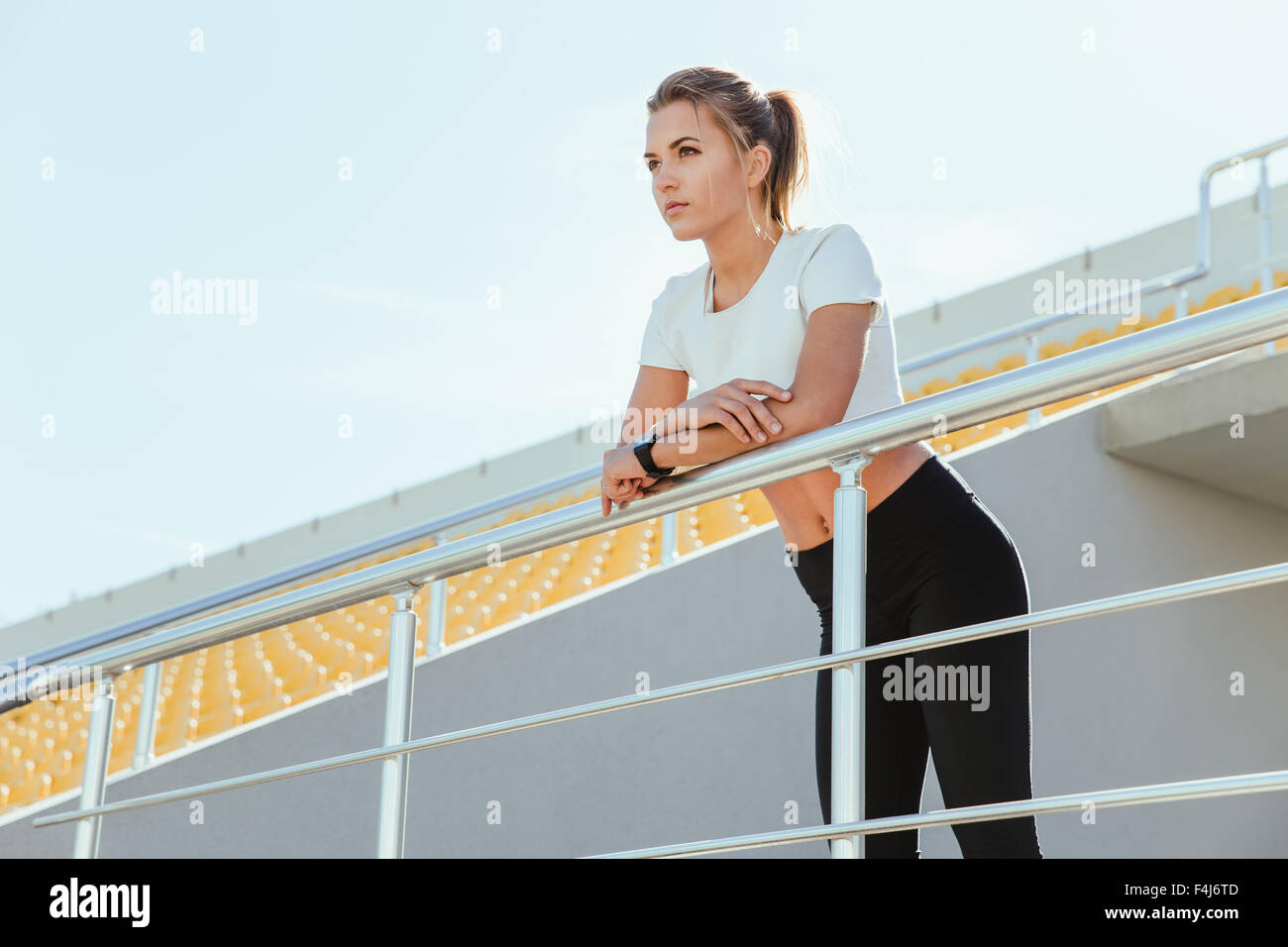 Portrait of a beautiful woman in sports wear standing on outdoor stadium Stock Photo