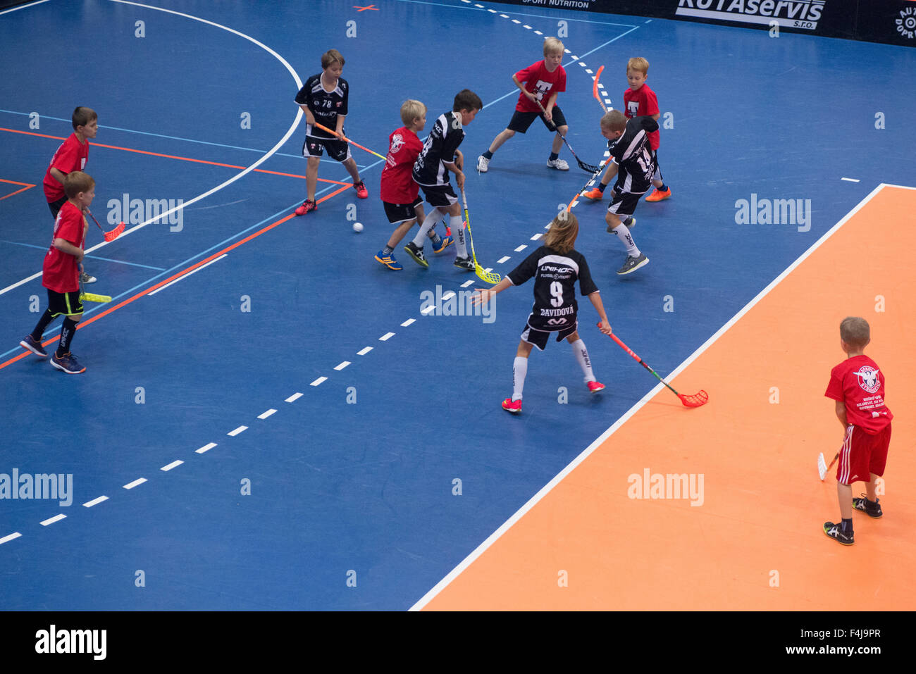 Children boys schoolchildren playing floorball (floor hockey) match in