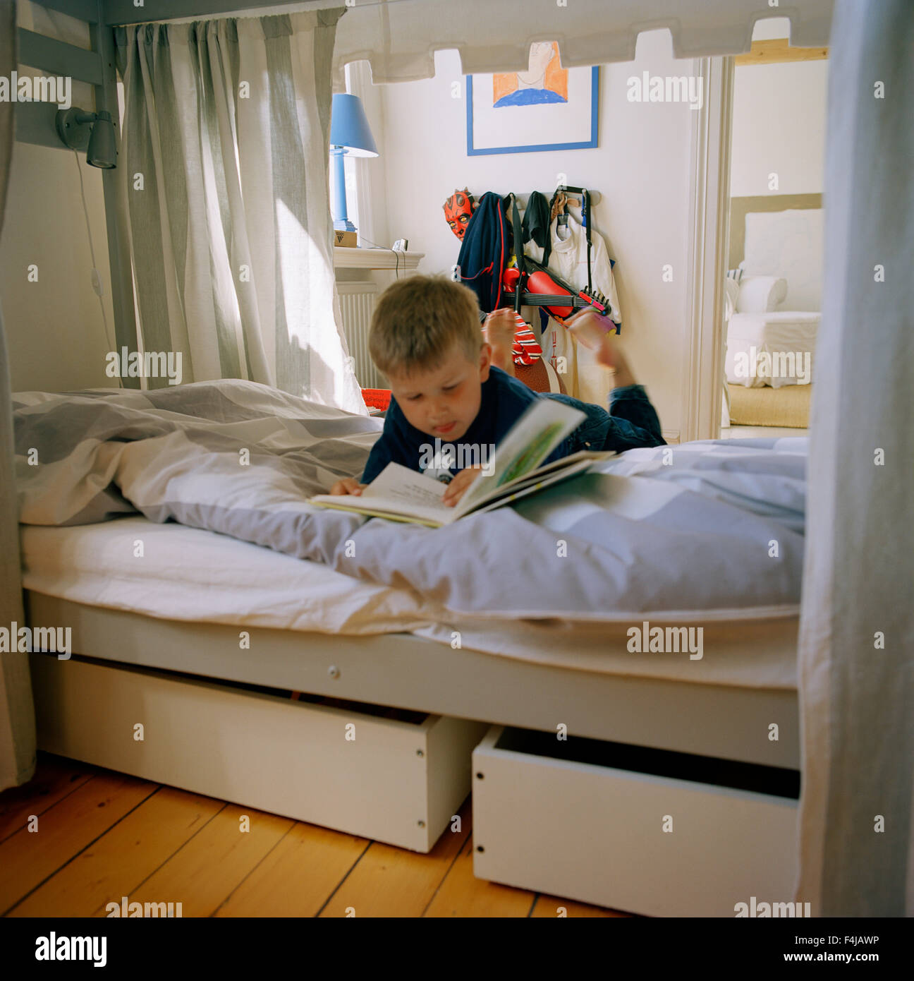 Boy reading a book in bed, Sweden Stock Photo Alamy