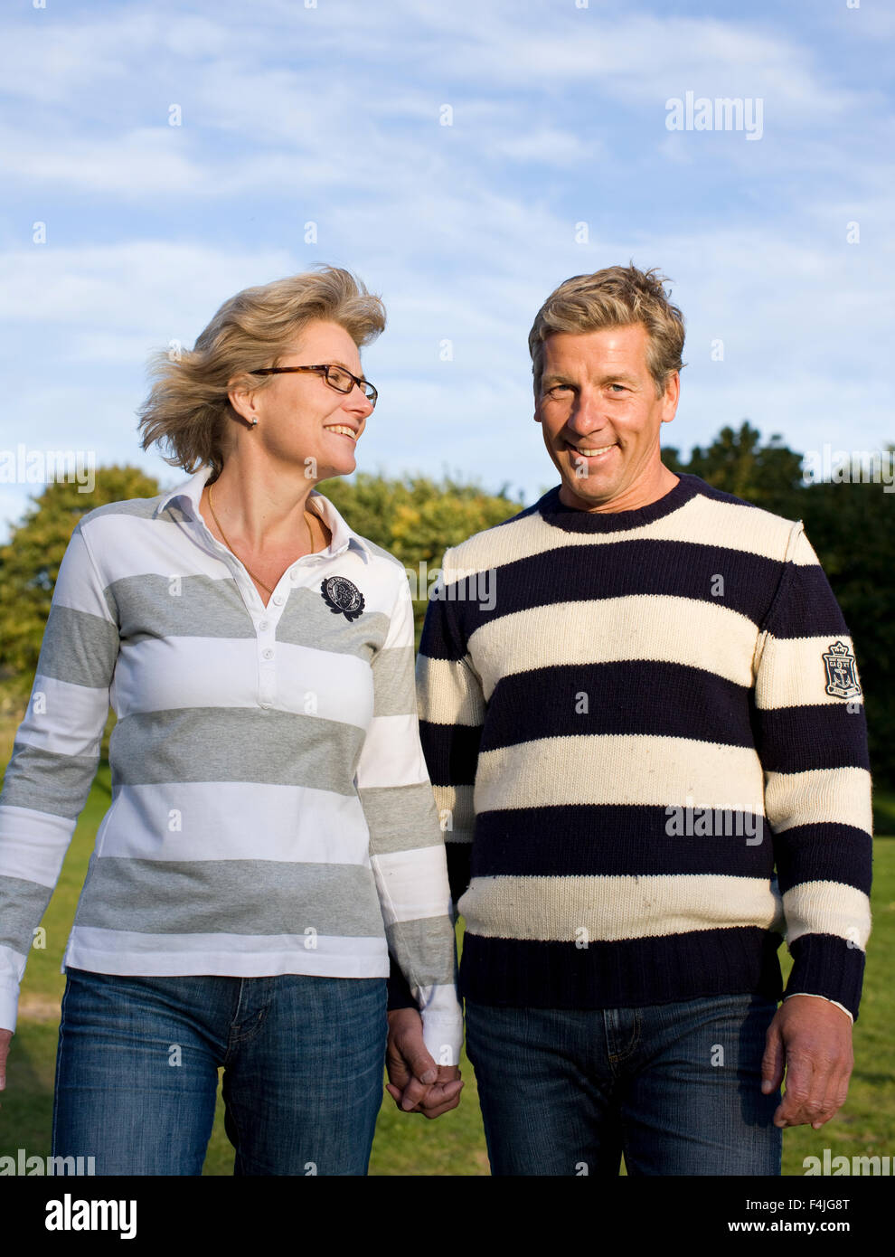 Couple holding hands in park Stock Photo - Alamy