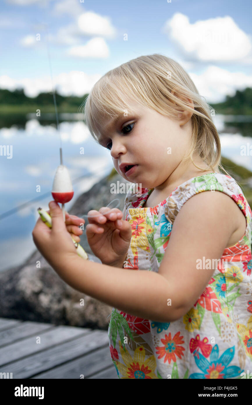 Girl looking at fishing hook Stock Photo