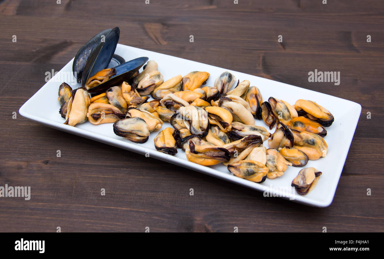 Mussels without shells on tray on wooden table Stock Photo Alamy