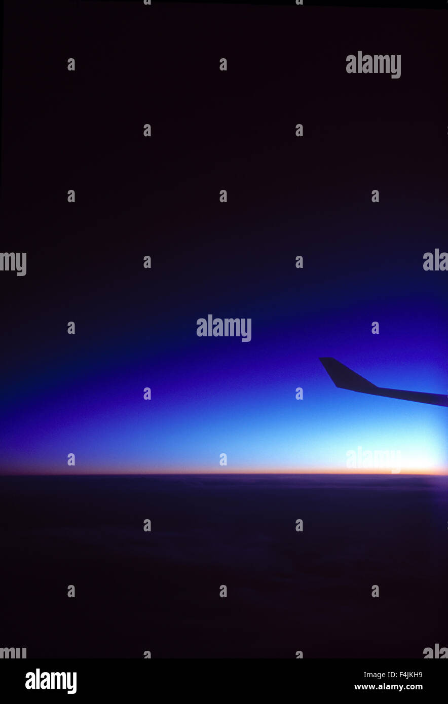 Aeroplane wing over sea at dawn Stock Photo