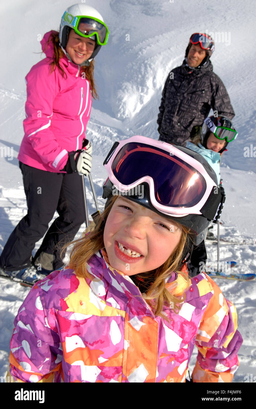 Kids (6-7, 8-9) with parents on ski holidays Stock Photo