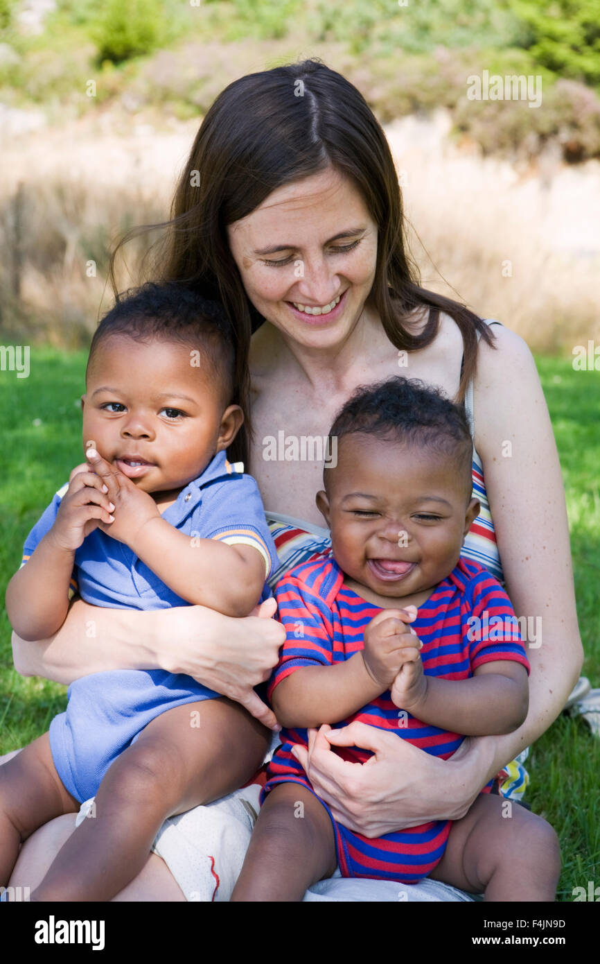 Sweden, Gothenburg, mother embracing sons (12-17 months) outdoors Stock Photo
