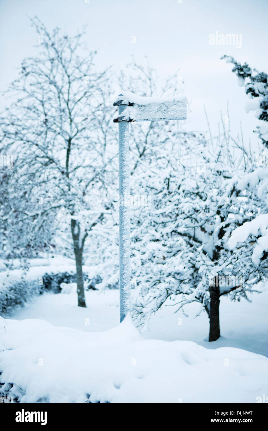 Sweden, direction sign covered with snow on rural crossroads Stock Photo