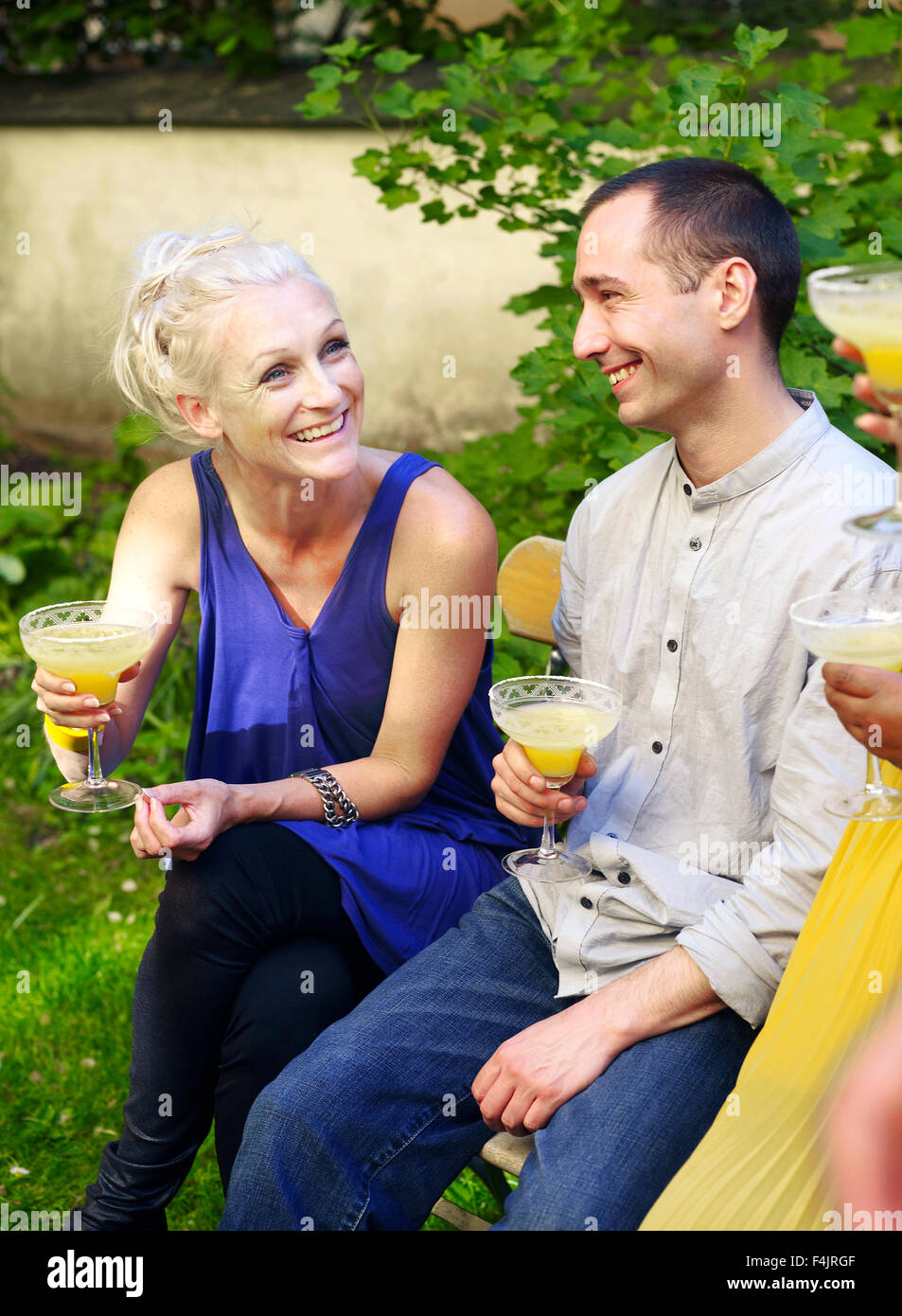 Friends drinking orange juice in backyard Stock Photo Alamy