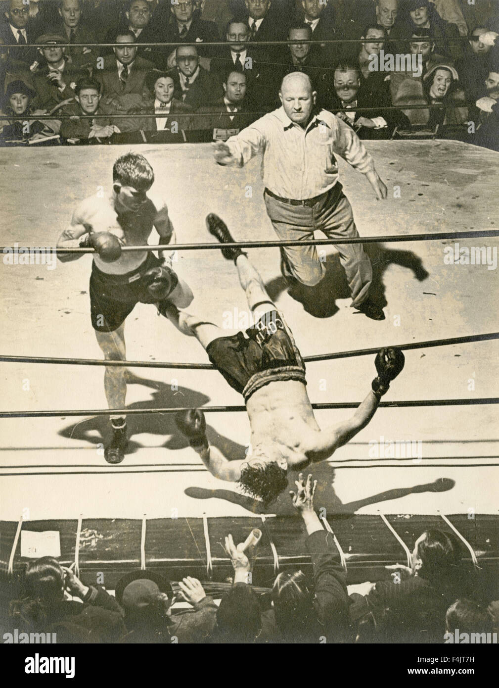 The boxer Frankie Vallerino throws Bert Collima over the ropes of the ring Stock Photo