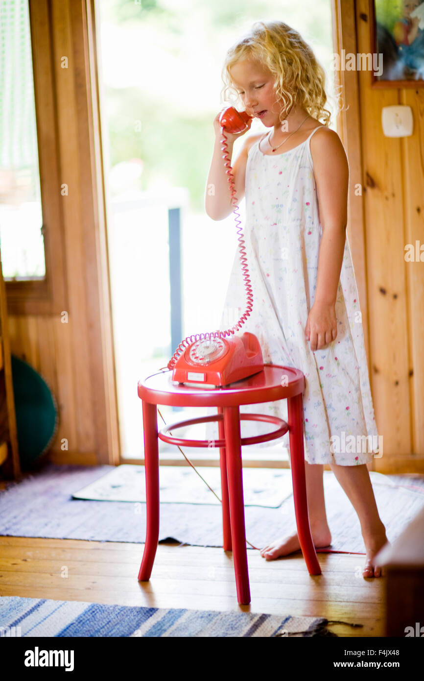 Girl talking on landline phone Stock Photo
