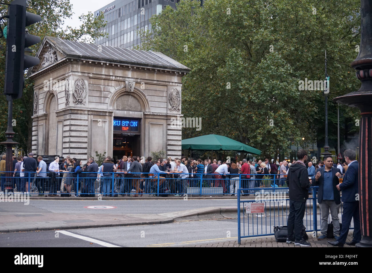Drinkers outside Euston Tap bar, Euston Station, London, England Stock