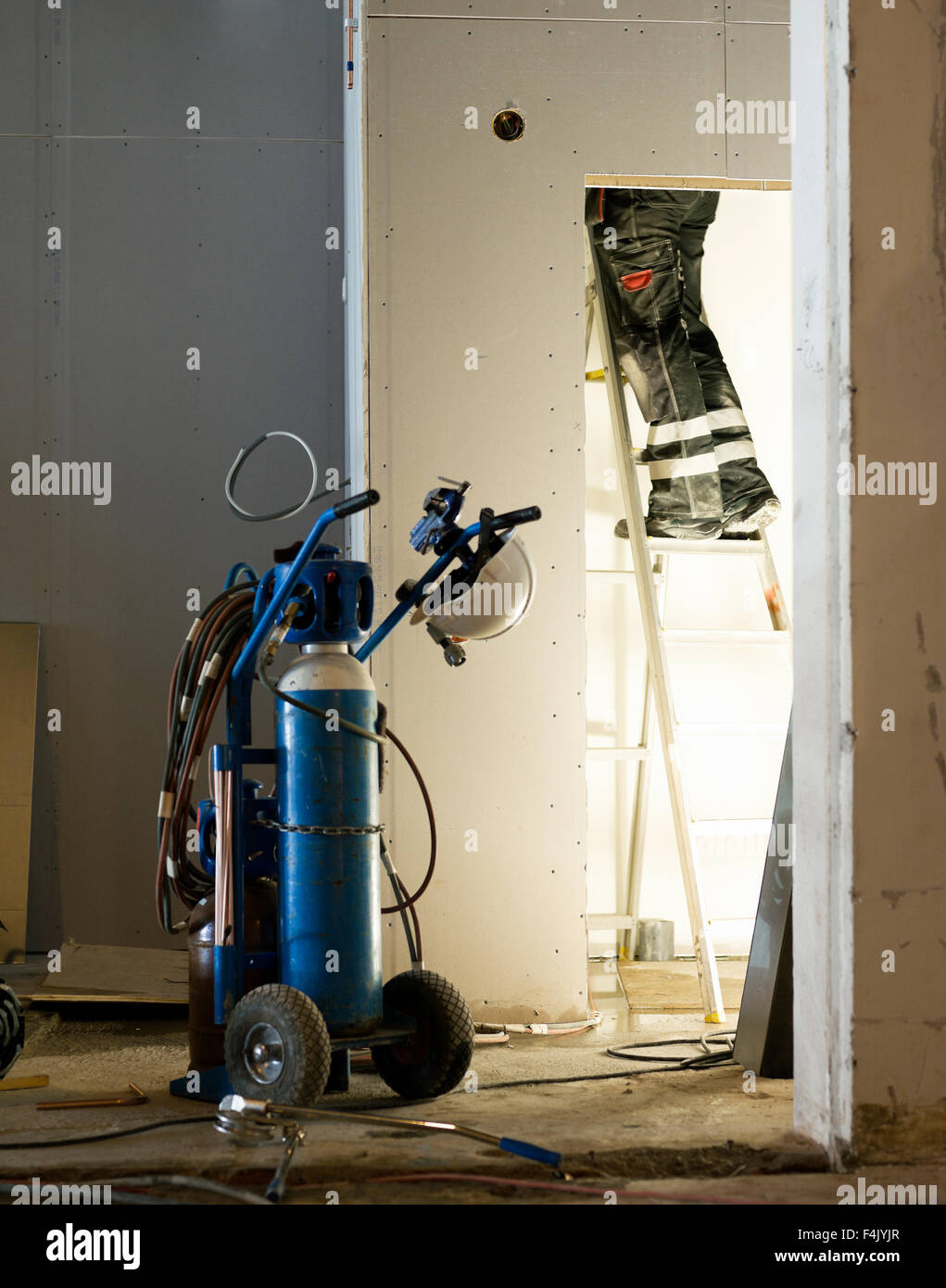 Man standing on ladder with work tool Stock Photo